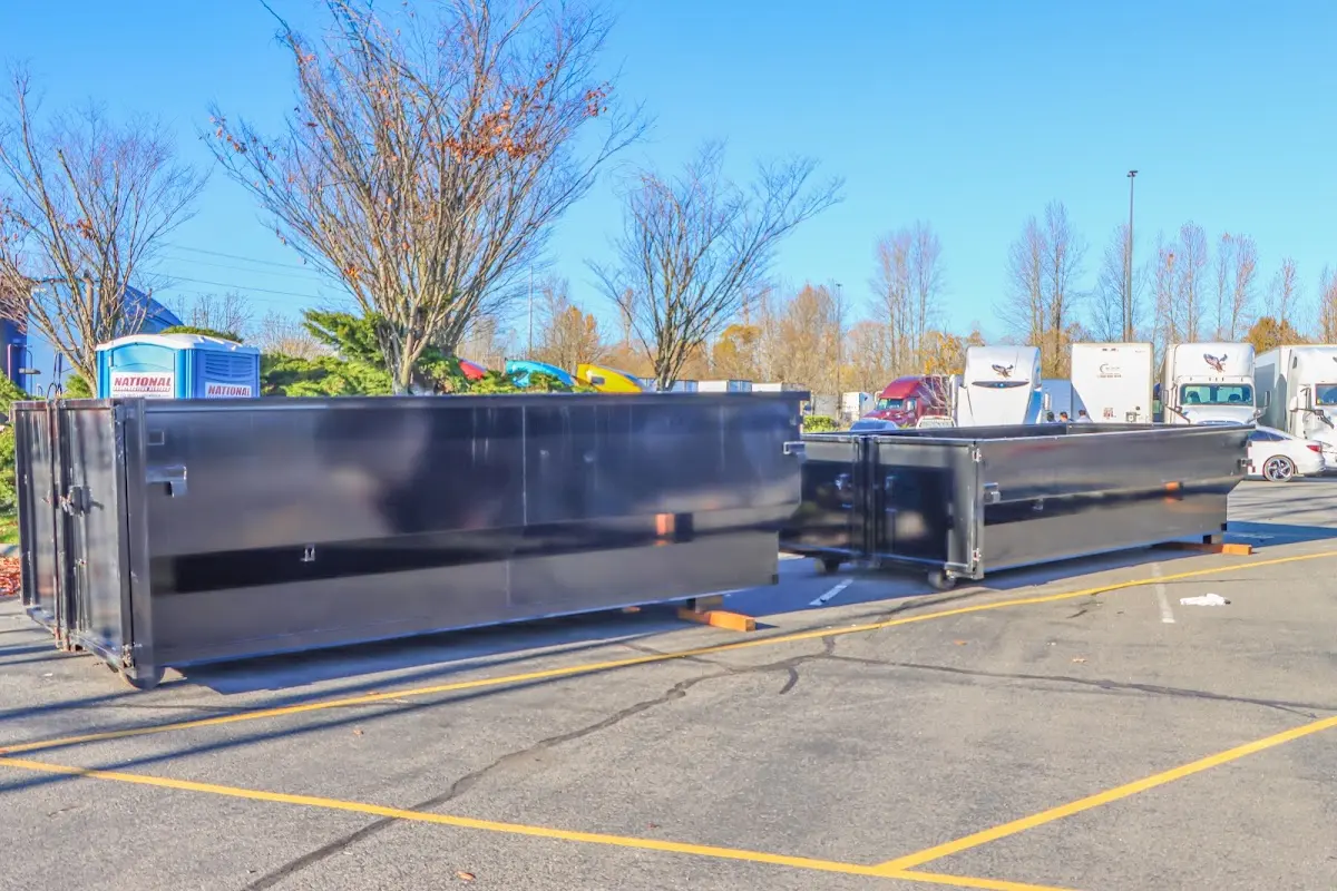 Professional dumpster rental service with roll-off container on residential driveway in Marple